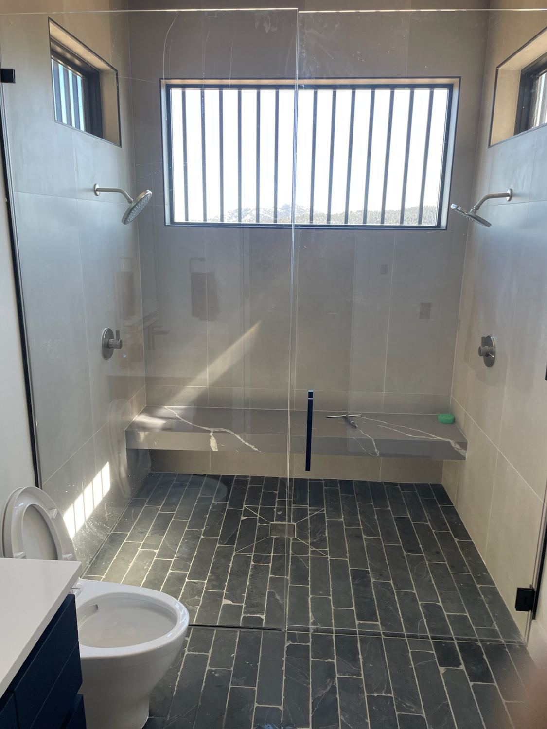 Bathroom remodel with a frameless glass shower enclosure for a homeowner in Littleton, CO.