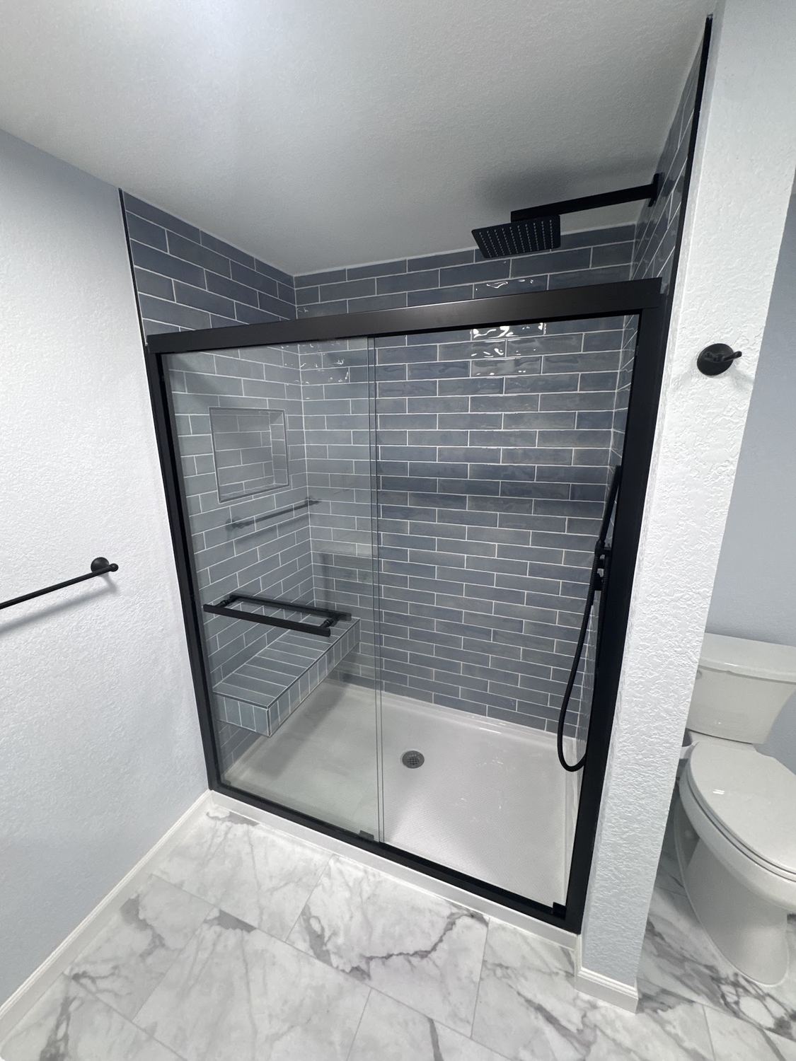Bathroom remodel with black-frame glass shower